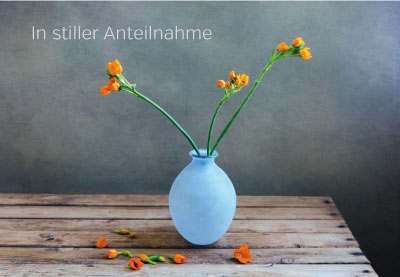 Trauer - orange Blumen in hellblauer Vase